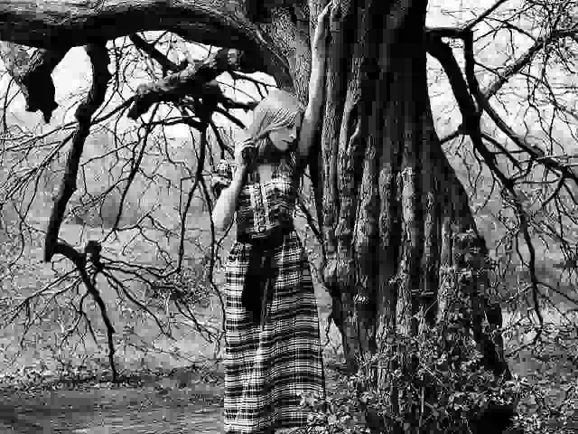 fashion model posing by an old tree