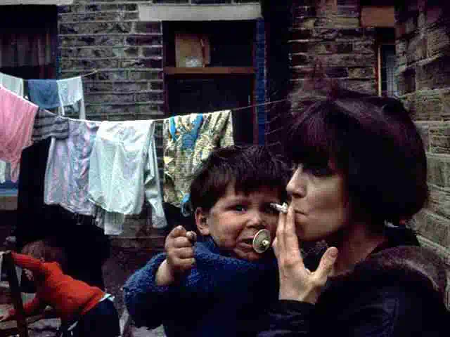 smoking bradford slum resident with child in arms