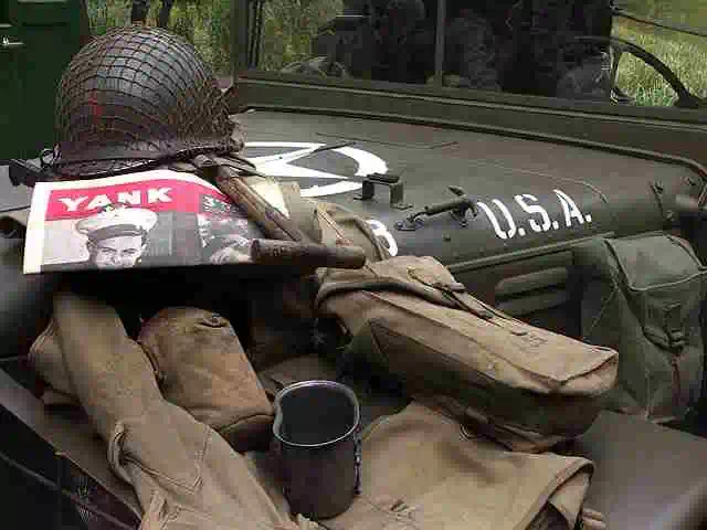 american army rifle helmet and uniform on jeep bonnet